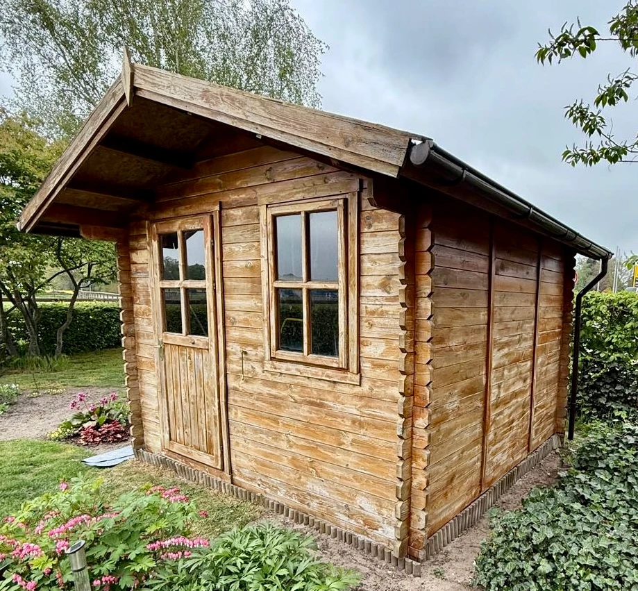 Holz-Gartenhaus mit verblasster, ausgegrauter Lasur
